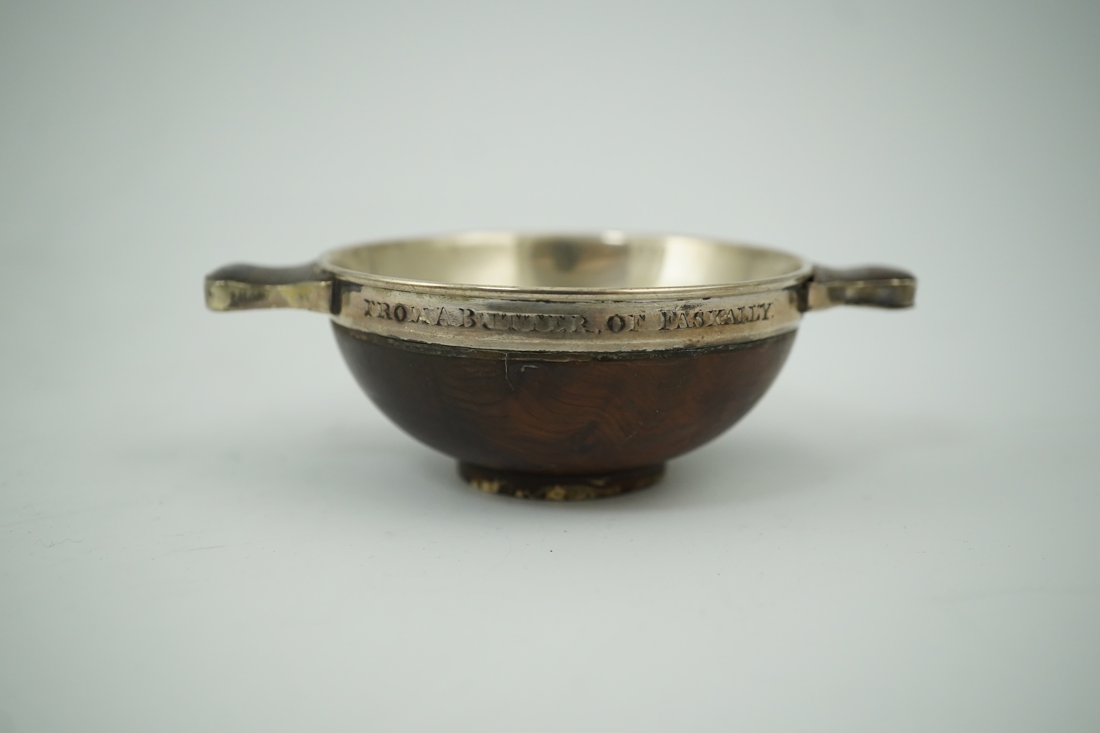 An early 19th century silver mounted yew wood quaich, inscribed 'Scuab As E' to the bowl and 'To Charles Gibson / From A Butter of Faskally' around the rim, dated 1830 beneath one handle, 10.6cm over handles. Condition -